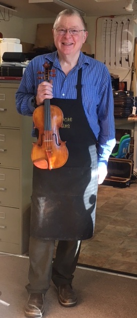 Jeff Loen holding violin in shop...